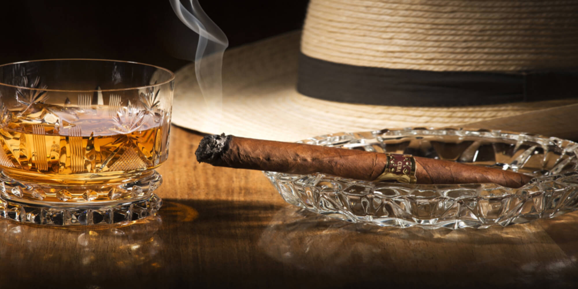 Cigar drink and hat on table